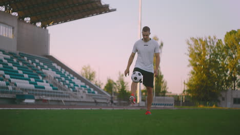 Tilt-up-with-slow-motion-of-male-from-professional-soccer-league-juggling-ball-on-leg-in-outdoor-playing-field-on-sunny-summer-day